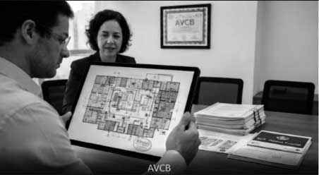 Profissionais realizando vistoria de segurança para obtenção do AVCB em edificação comercial seguindo normas técnicas exigidas.
