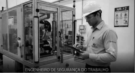 Engenheiro de segurança do trabalho realizando vistoria técnica em ambiente industrial com uso de equipamento de proteção individual.