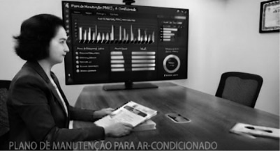 Técnico especializado realizando limpeza e manutenção preventiva em unidade de ar-condicionado comercial.