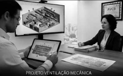 Engenheiro analisando planta de sistema de exaustão e renovação de ar para um Projeto Ventilação Mecânica eficiente em ambiente comercial.