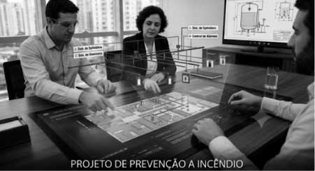 Engenheiro conferindo planta de projeto de prevenção contra incêndio com sistema de hidrantes e sinalização de emergência.